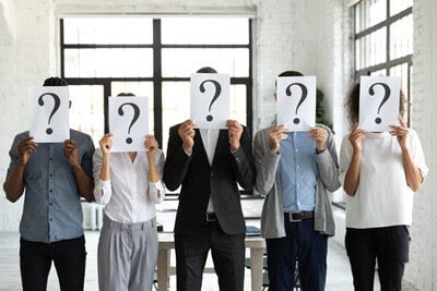 People holding question marks in front of their face