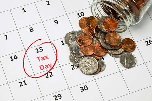 us tax calendar with 15th highlighted as tax day and a pot of us coins spilled