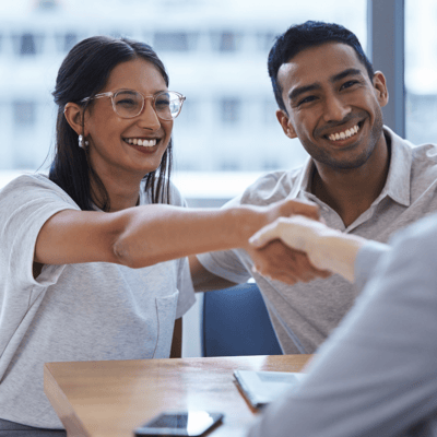 Man and woman shaking hands with a financial advisor